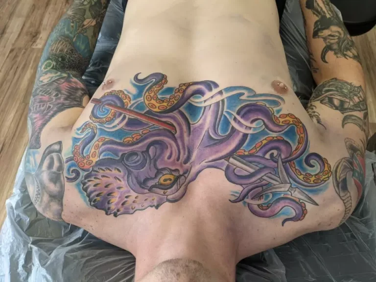 A man's back adorned with an octopus tattoo as he prepares for a traditional tattoo.