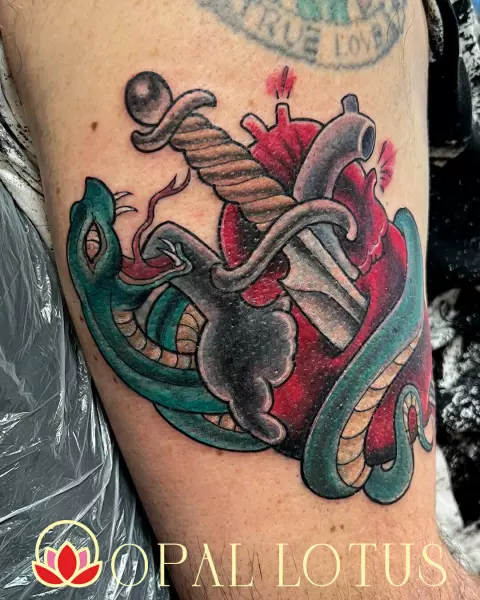 A traditional tattoo featuring a heart adorned with a snake, located in Katy / Houston.