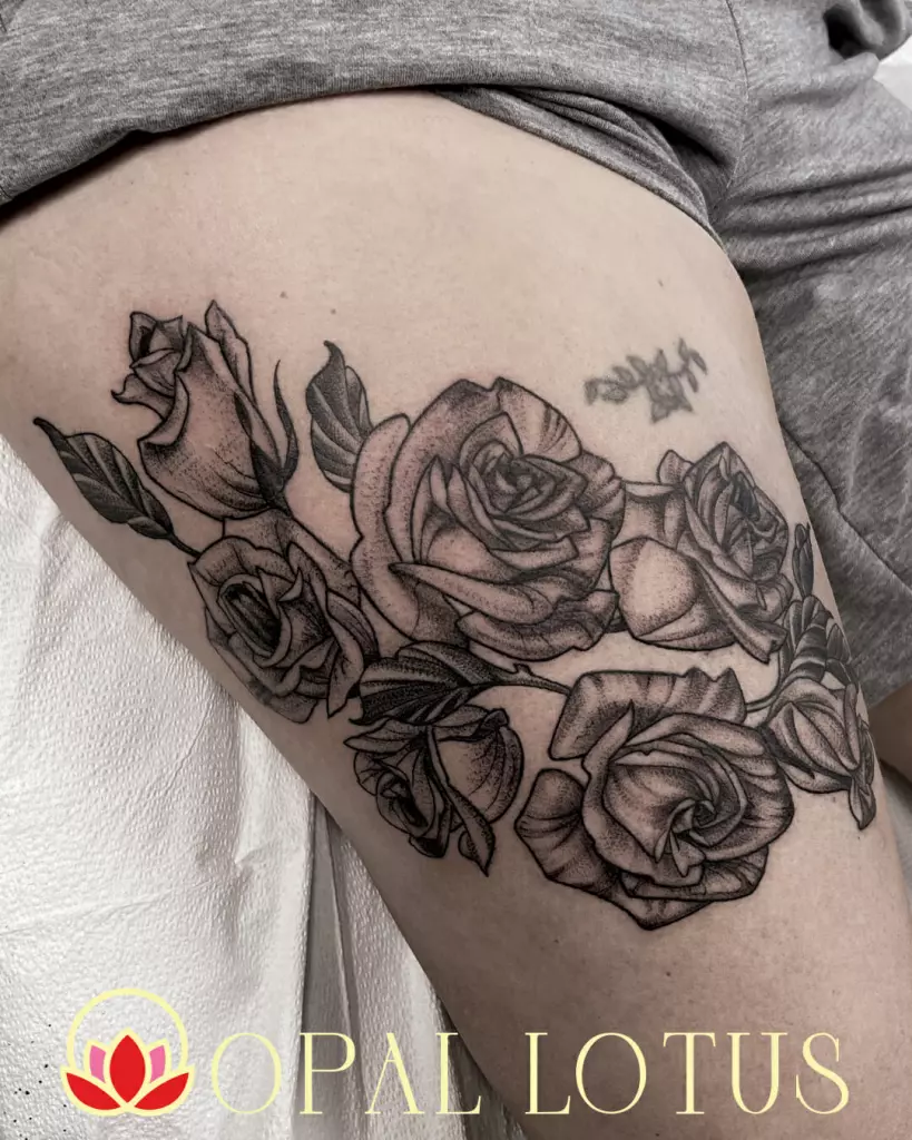 An illustrative black and grey thigh tattoo of roses in Katy.