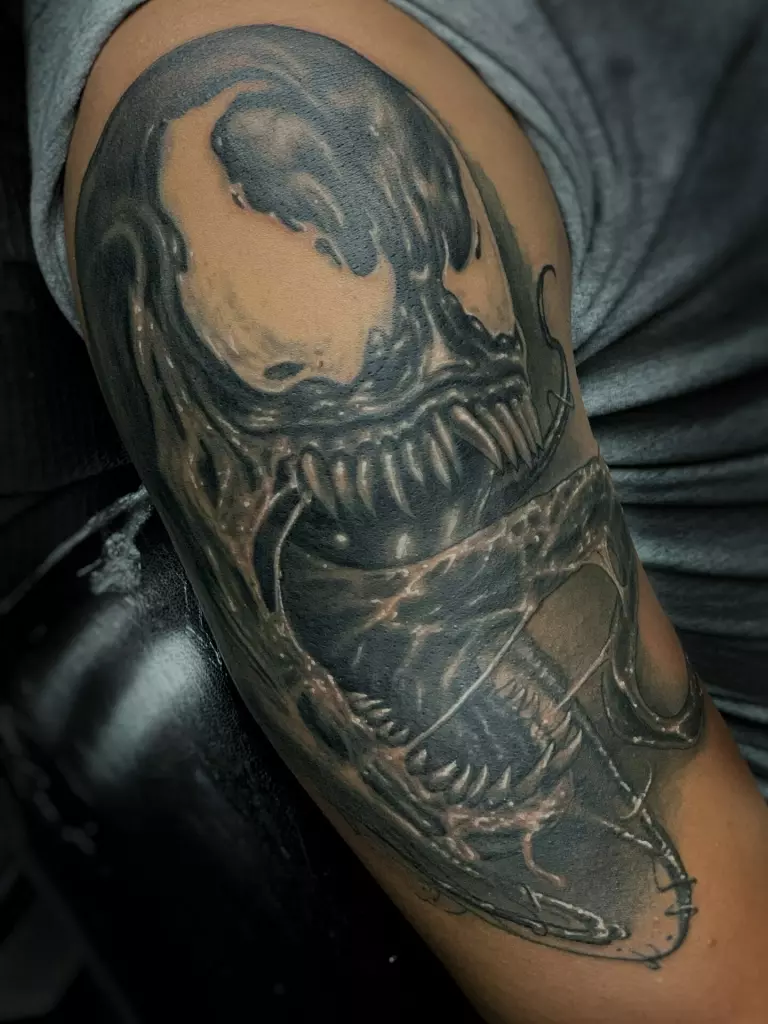 A realistic black work venom tattoo on Travis' arm.