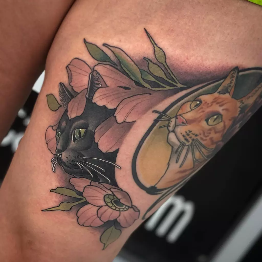 A neotraditional tattoo of a cat with Japanese-inspired flowers on the thigh.