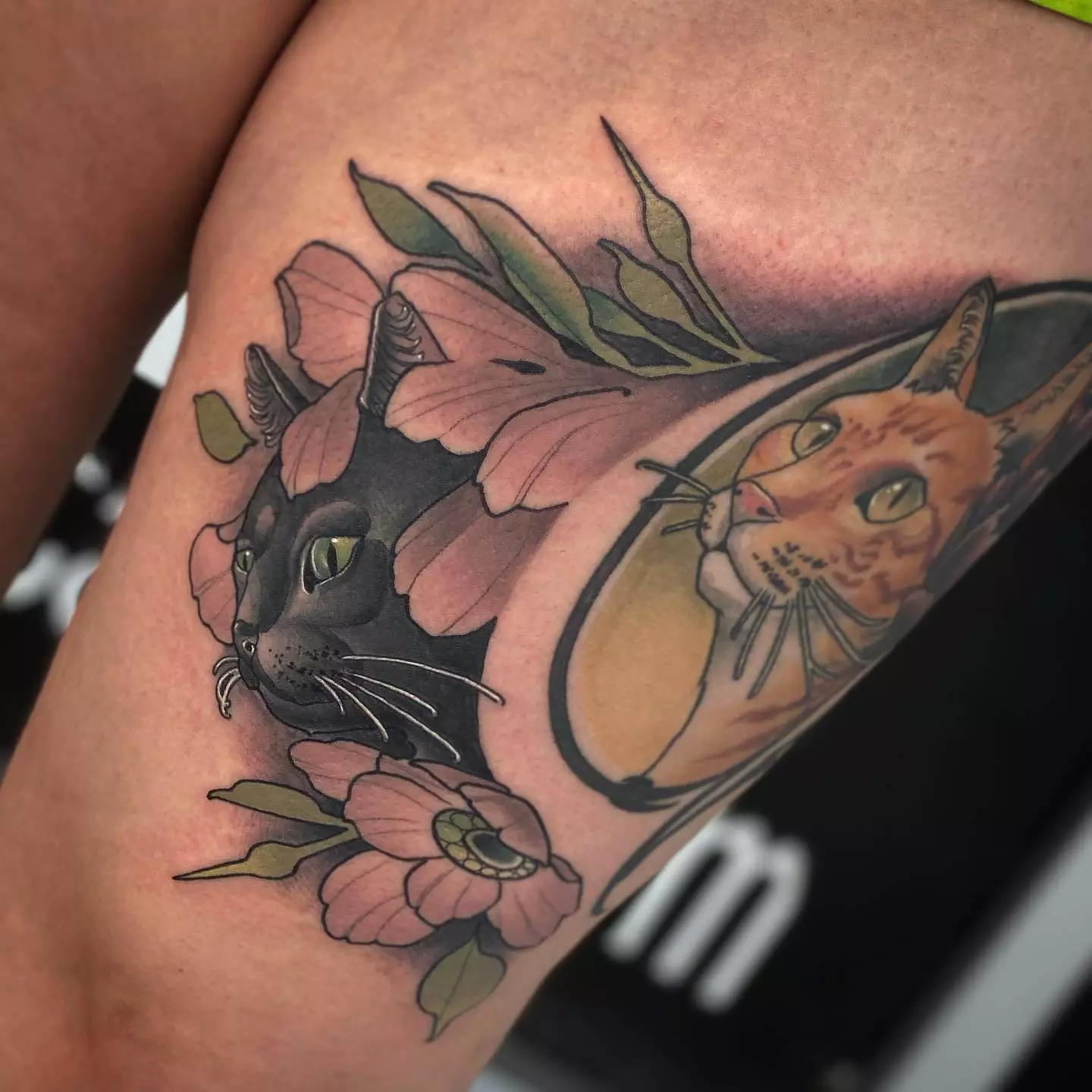 A thigh tattoo featuring a cat and opal lotus flowers.