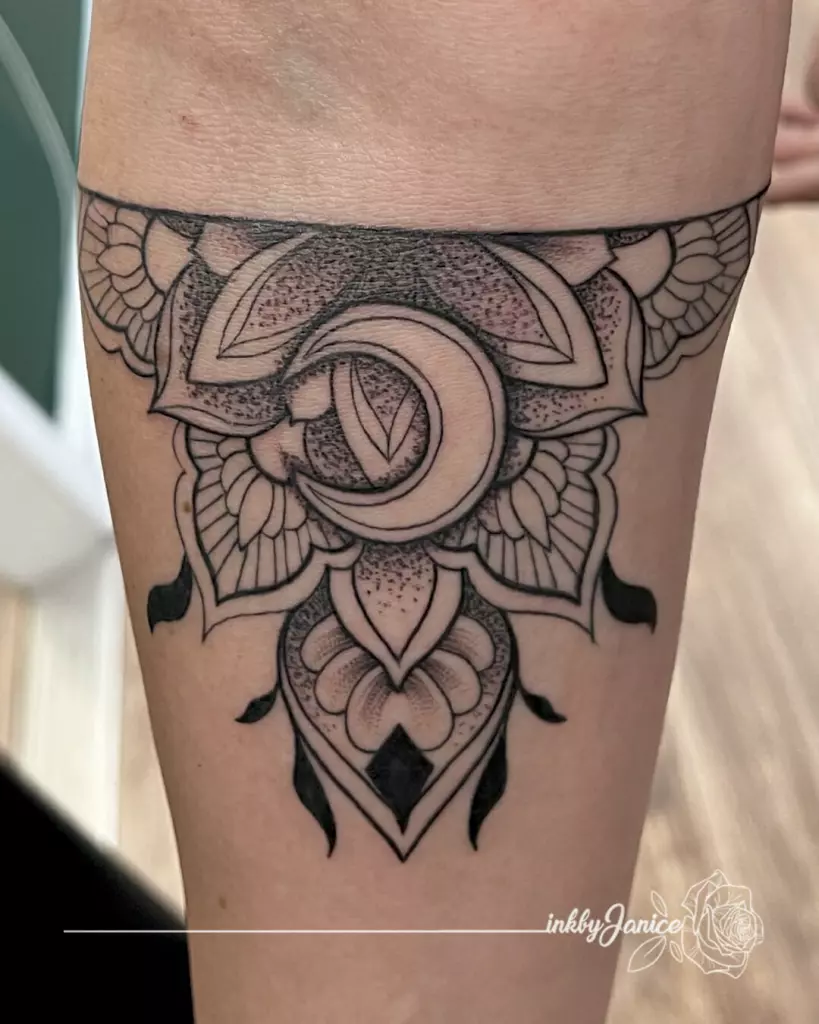 A Black and Grey crescent and moon tattoo on Janice's thigh.