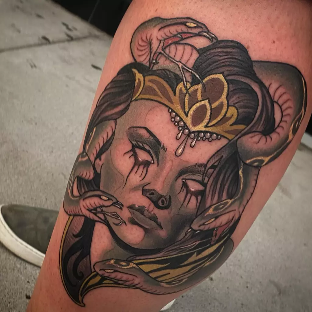 A blackwork tattoo featuring a woman with snakes on her thigh.